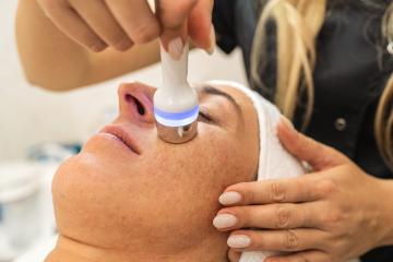 Side view of woman receiving hydrafacial therapy on forehead at - Stock Photo or Stock Video of rcfotostock | RC Photo Stock