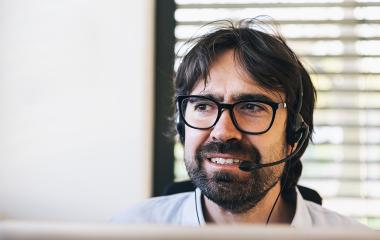 Smiling friendly handsome male call centre operator work in a office : Stock Photo or Stock Video Download rcfotostock photos, images and assets rcfotostock | RC Photo Stock.: