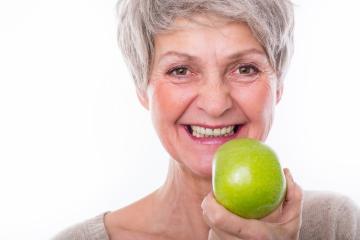 Smiling older woman with short gray hair holding a green apple close to her face, showcasing healthy teeth and vibrant energy against a bright white background : Stock Photo or Stock Video Download rcfotostock photos, images and assets rcfotostock | RC Photo Stock.: