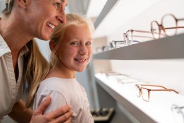 Smiling woman and child looking at new eyeglasses in optical store- Stock Photo or Stock Video of rcfotostock | RC Photo Stock