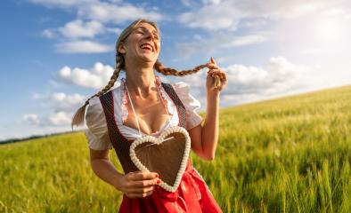 smiling woman in Bavarian dress holding a gingerbread heart in a wheat field, laughing and playing with her braid celebrating Oktoberfest or dult festival in munich, with copyspace for text : Stock Photo or Stock Video Download rcfotostock photos, images and assets rcfotostock | RC Photo Stock.: