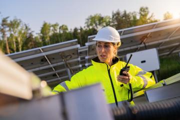 Solar technician with walkie-talkie checking solar panel in solar park. Alternative energy ecological concept image.- Stock Photo or Stock Video of rcfotostock | RC Photo Stock