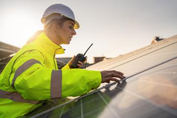 Solar technician with walkie-talkie inspecting solar panels at dusk. Alternative energy ecological concept image.- Stock Photo or Stock Video of rcfotostock | RC Photo Stock