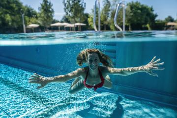 Split above and underwater photo of a woman swimming in pool during summer vacation in a hotel- Stock Photo or Stock Video of rcfotostock | RC Photo Stock