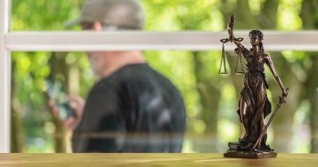 Statue of Justice - lady justice or Iustitia / Justitia the Roman goddess of Justice in a lawyer office with a man using a smartphone : Stock Photo or Stock Video Download rcfotostock photos, images and assets rcfotostock | RC Photo Stock.: