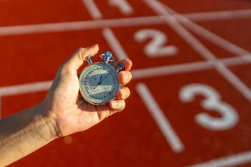 Stopwatch held over running track numbers, sports timing concept, athletic competition backdrop : Stock Photo or Stock Video Download rcfotostock photos, images and assets rcfotostock | RC Photo Stock.: