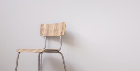 Student chair in front of a grey wall, with copy space for individual text - Stock Photo or Stock Video of rcfotostock | RC-Photo-Stock