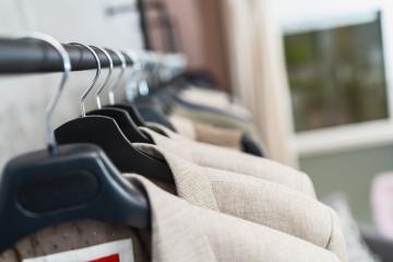 Suits on hangers in a row, blurred background with focus on beige suit and hanger at a store- Stock Photo or Stock Video of rcfotostock | RC Photo Stock