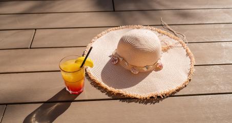 Summer cocktail with straw hat on a wooden deck, symbolizing relaxation and vacation vibes- Stock Photo or Stock Video of rcfotostock | RC Photo Stock