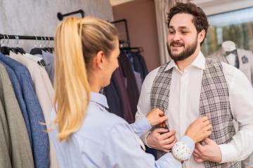 Tailor adjusting a waistcoat on a smiling client in a clothing boutique- Stock Photo or Stock Video of rcfotostock | RC Photo Stock