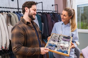 Tailor and customer smiling over a selection of bow ties in a clothing store- Stock Photo or Stock Video of rcfotostock | RC Photo Stock