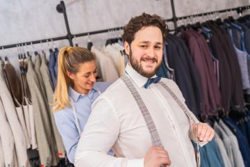 Tailor fastening a happy man's suspenders in a bright clothing store : Stock Photo or Stock Video Download rcfotostock photos, images and assets rcfotostock | RC Photo Stock.: