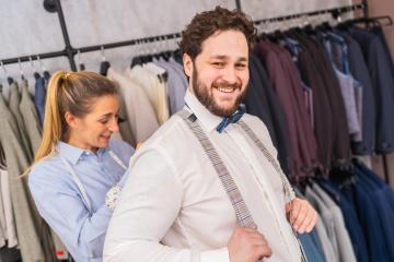 Tailor fastening suspenders for a smiling man in a clothing boutique : Stock Photo or Stock Video Download rcfotostock photos, images and assets rcfotostock | RC Photo Stock.: