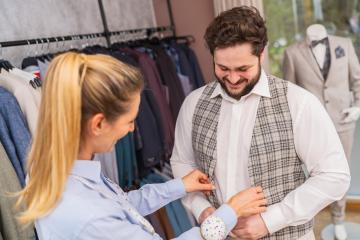 Tailor fitting a checkered waistcoat on a client, both are smiling : Stock Photo or Stock Video Download rcfotostock photos, images and assets rcfotostock | RC Photo Stock.: