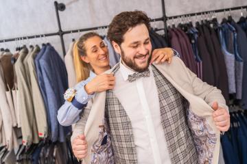 Tailor helping a man try on a jacket in a boutique, both are smiling : Stock Photo or Stock Video Download rcfotostock photos, images and assets rcfotostock | RC Photo Stock.: