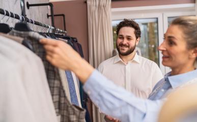 Tailor holding up a checkered jacket for a smiling male customer in a wedding store : Stock Photo or Stock Video Download rcfotostock photos, images and assets rcfotostock | RC Photo Stock.: