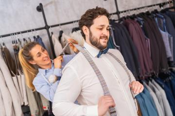 Tailor playfully pulling on client's suspenders, both smiling in a clothing store : Stock Photo or Stock Video Download rcfotostock photos, images and assets rcfotostock | RC Photo Stock.: