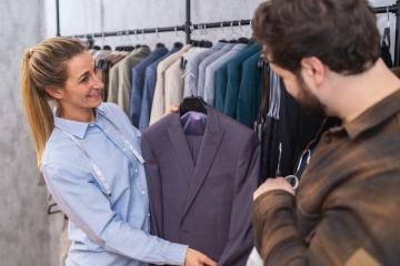 Tailor presenting a purple suit to a customer, engaging in a conversation about it : Stock Photo or Stock Video Download rcfotostock photos, images and assets rcfotostock | RC Photo Stock.: