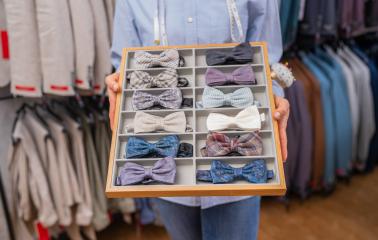 Tailor presenting a selection of bow ties in a compartmentalized tray- Stock Photo or Stock Video of rcfotostock | RC Photo Stock