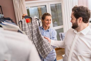 Tailor showing a checked jacket to a smiling male customer in a boutique- Stock Photo or Stock Video of rcfotostock | RC Photo Stock