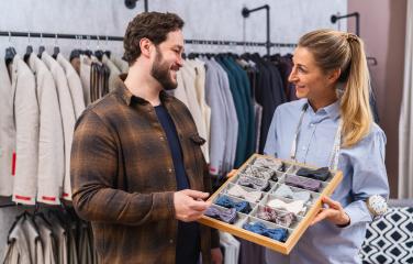 Tailor showing bow ties to a male customer in a clothing store- Stock Photo or Stock Video of rcfotostock | RC Photo Stock