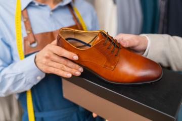 Tailor woman showcasing a brown leather dress shoe beside a box : Stock Photo or Stock Video Download rcfotostock photos, images and assets rcfotostock | RC Photo Stock.: