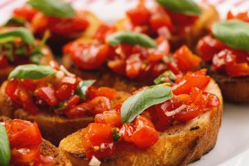 Tasty savory tomato Italian appetizers, or bruschetta, on slices of toasted baguette garnished with basil, close up : Stock Photo or Stock Video Download rcfotostock photos, images and assets rcfotostock | RC-Photo-Stock.: