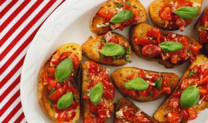 Tasty savory tomato Italian appetizers, or bruschetta, on slices of toasted baguette garnished with basil- Stock Photo or Stock Video of rcfotostock | RC Photo Stock