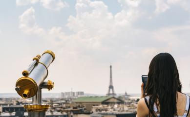 Telescope with view to the Eiffel Tower and woman taking pictures with a smartphone in Paris- Stock Photo or Stock Video of rcfotostock | RC Photo Stock