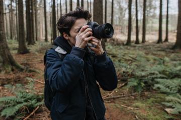 The photographer pay attention to take a photo in a beautiful forest. Adventure travel with camera in the nature.- Stock Photo or Stock Video of rcfotostock | RC Photo Stock