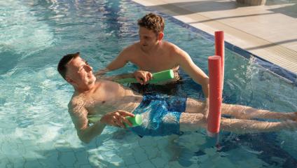 Therapist and patient using pool noodles for rehab exercises in  : Stock Photo or Stock Video Download rcfotostock photos, images and assets rcfotostock | RC Photo Stock.: