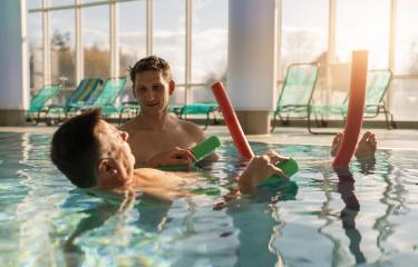 Therapist assisting patient with leg exercises using pool noodle : Stock Photo or Stock Video Download rcfotostock photos, images and assets rcfotostock | RC Photo Stock.:
