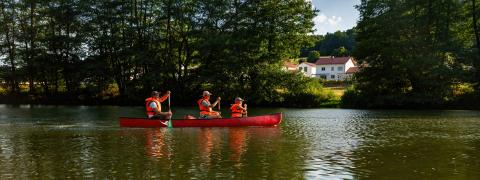 thre people in life jackets paddling a red canoe on a tranquil river with lush greenery in the background at summer in germany.  Family on kayak ride. Wild nature and water fun on summer vacation. : Stock Photo or Stock Video Download rcfotostock photos, images and assets rcfotostock | RC Photo Stock.: