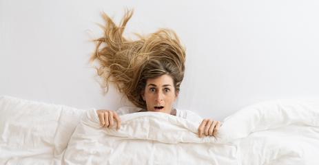 Top view of a beautiful woman that is surprise and looking at camera while lying in bed under blanket- Stock Photo or Stock Video of rcfotostock | RC Photo Stock