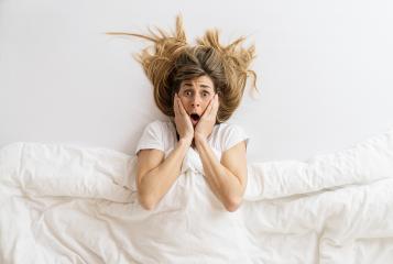 Top view of a shocked woman that looks at camera while lying in bed under blanket, copyspace for your individual text.- Stock Photo or Stock Video of rcfotostock | RC-Photo-Stock