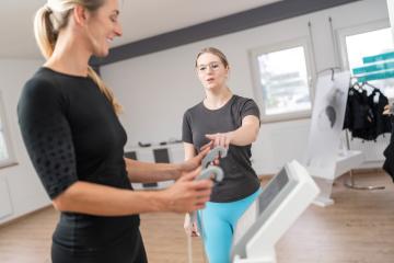 Trainer explaining body composition scale for Inbody analysis test  client holding handles in a fitness studio, both looking engaged.- Stock Photo or Stock Video of rcfotostock | RC Photo Stock