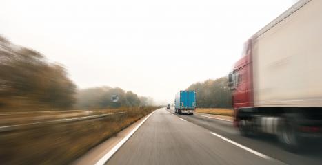 Trucks driving on the highway turning towards the horizon in an autumn landscape with mist, copyspace for your individual text.- Stock Photo or Stock Video of rcfotostock | RC-Photo-Stock
