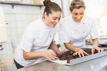 Two bakers arranging chocolate-covered gingerbreads on a tray in a bakery, carefully preparing the freshly made treats in a professional baking environment : Stock Photo or Stock Video Download rcfotostock photos, images and assets rcfotostock | RC Photo Stock.: