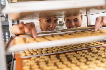 Two bakers smiling and checking trays of freshly baked cookies on a cooling rack in a bakery, examining the baked goods in a professional baking environment : Stock Photo or Stock Video Download rcfotostock photos, images and assets rcfotostock | RC Photo Stock.: