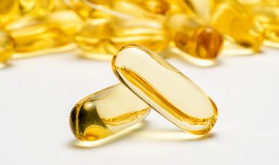 Two capsules Omega 3 and many other of capsules on blurred background. Health care concept image- Stock Photo or Stock Video of rcfotostock | RC Photo Stock