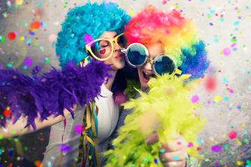 Two cheerful women dressed in colorful wigs, oversized glasses, feather boas, and surrounded by confetti, enjoying a fun and vibrant party atmosphere filled with laughter and celebration : Stock Photo or Stock Video Download rcfotostock photos, images and assets rcfotostock | RC Photo Stock.: