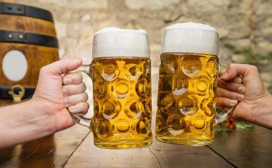 Two hands toasting with glasses with german beer and wooden barrel, Munich, Germany- Stock Photo or Stock Video of rcfotostock | RC Photo Stock