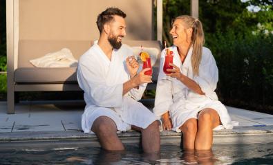Two people in white bathrobes toasting with cocktails by the poolside, enjoying the sunset- Stock Photo or Stock Video of rcfotostock | RC Photo Stock