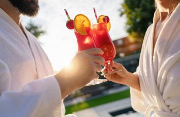 Two people in white bathrobes toasting with red cocktails in the sunlight, outdoors at spa wellness hotel : Stock Photo or Stock Video Download rcfotostock photos, images and assets rcfotostock | RC Photo Stock.: