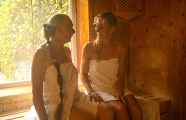 Two women in a finish sauna, smiling at each other, sunlight through window, wooden walls. Spa wellness hotel concept image- Stock Photo or Stock Video of rcfotostock | RC Photo Stock