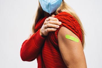 vaccine injection for corona virus COVID-19. Woman with face mask holding up her sweater sleeve and showing her arm with green Adhesive bandage Plaster after receiving vaccination : Stock Photo or Stock Video Download rcfotostock photos, images and assets rcfotostock | RC-Photo-Stock.: