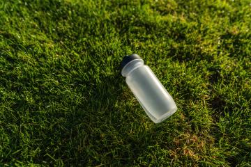 Water bottle lying on the grass in sunlight. Sports gear concept image : Stock Photo or Stock Video Download rcfotostock photos, images and assets rcfotostock | RC Photo Stock.: