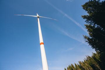 Wind turbine in the forest generating electricity with blue sky - energy conservation concept- Stock Photo or Stock Video of rcfotostock | RC Photo Stock