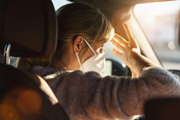 Woman driving car with a N95 FFP2 anti virus mask, protective mask against coronavirus, on a city street covering face by hand of bright sun light during a coronavirus outbreak, covid-19.- Stock Photo or Stock Video of rcfotostock | RC Photo Stock