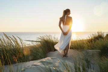 Woman finding freedom in dunes at Sunset. Sea beach view summer with woman dressed fashion style in white dress. vacation concept image- Stock Photo or Stock Video of rcfotostock | RC Photo Stock
